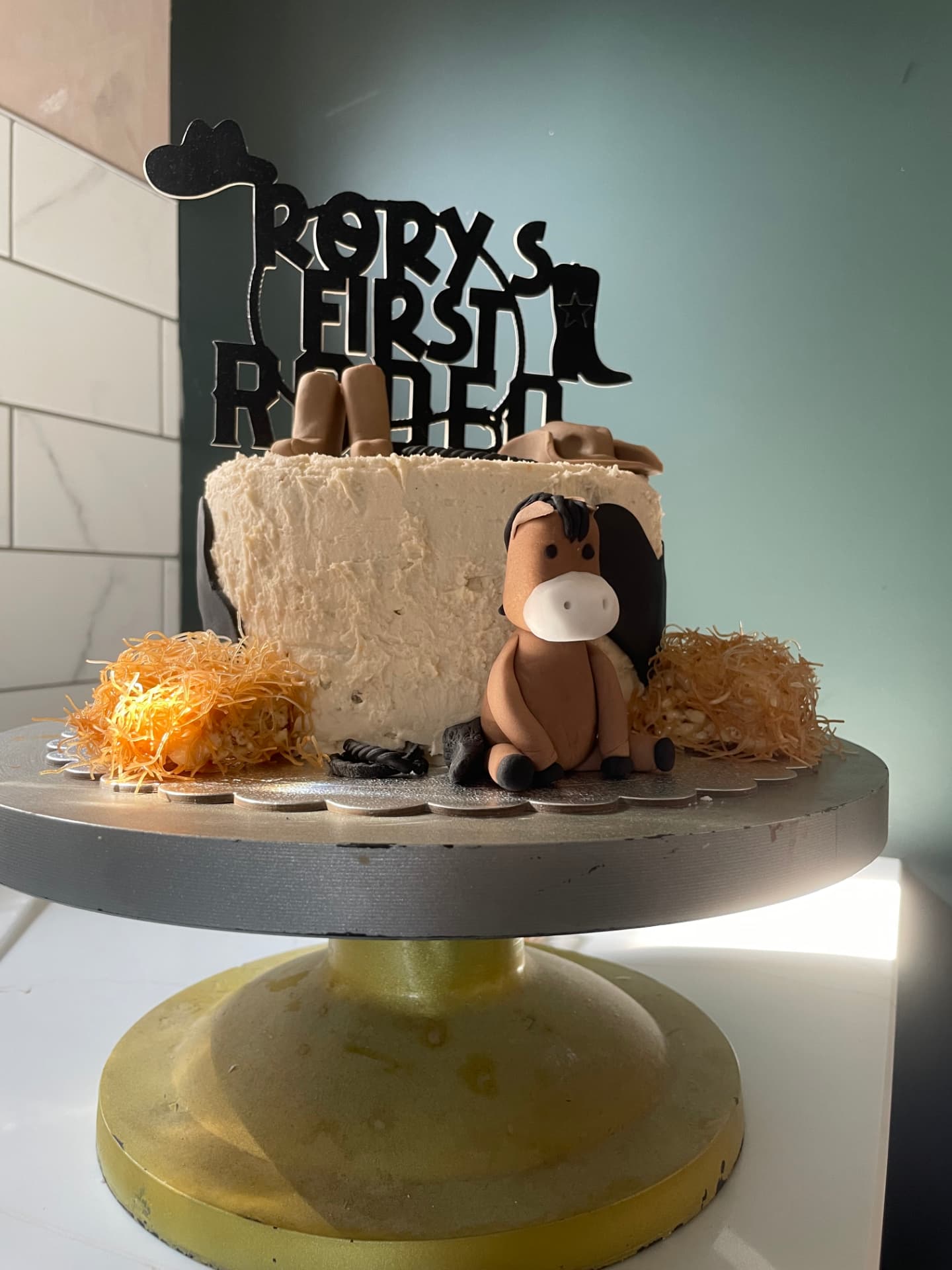 Rustic buttercream cowboy cake with a fondant horse, boots and a first rodeo topper